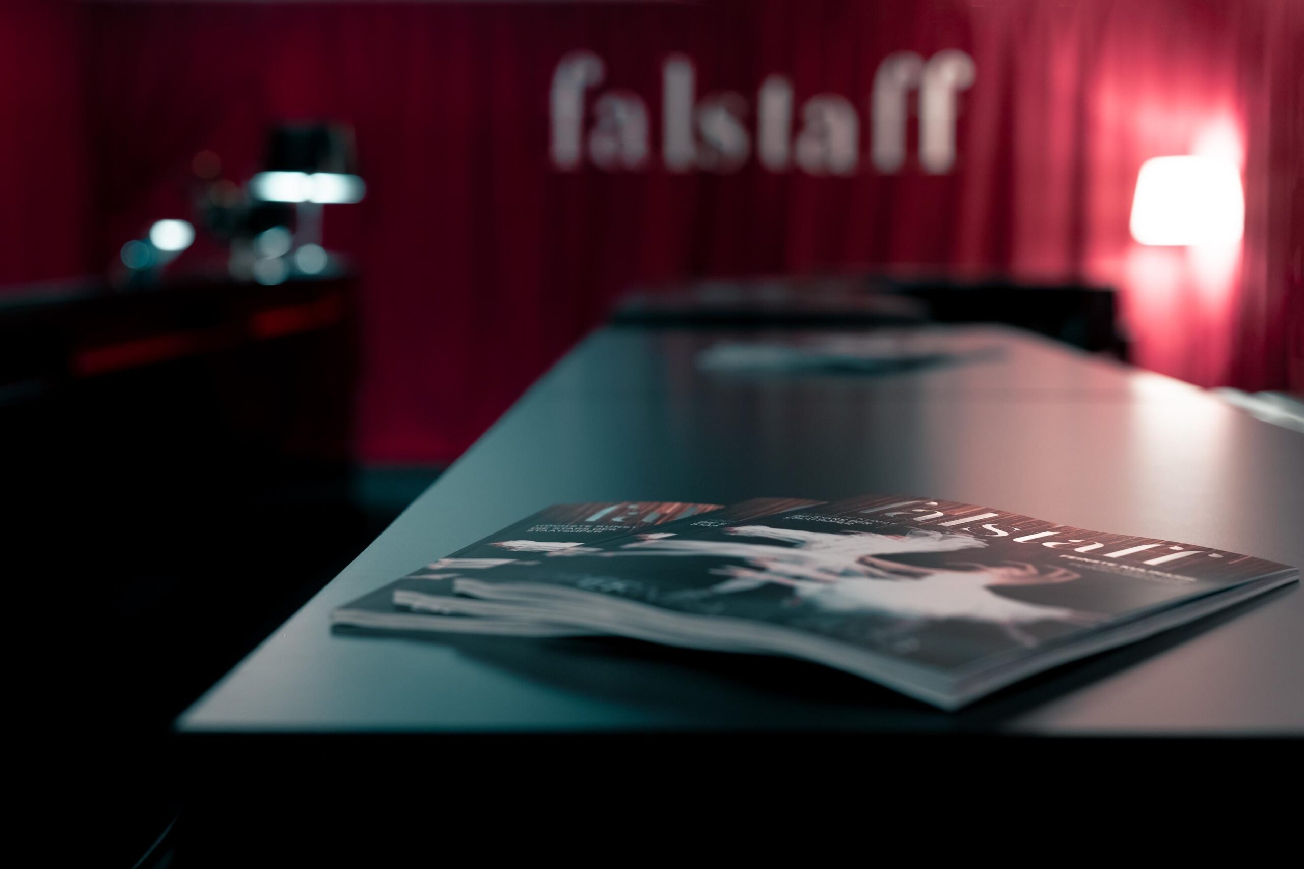 falstaff magazine with ballet dancers on table with dark red curtains in the back