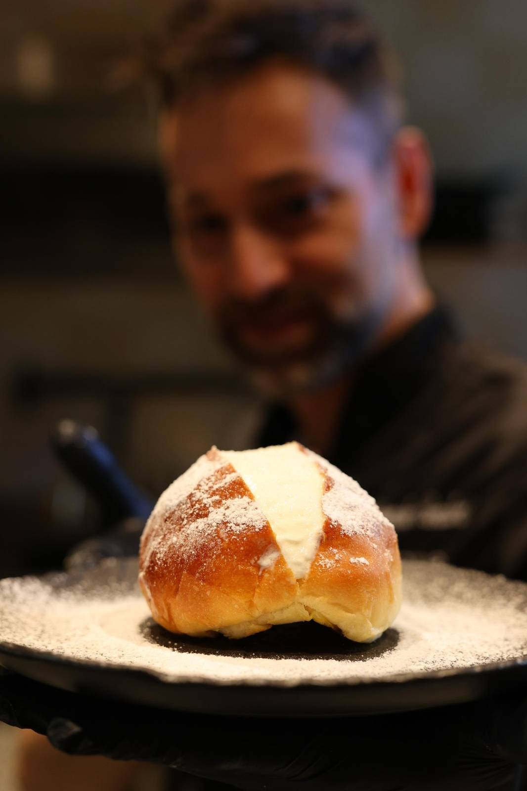 male chef with donut on plate